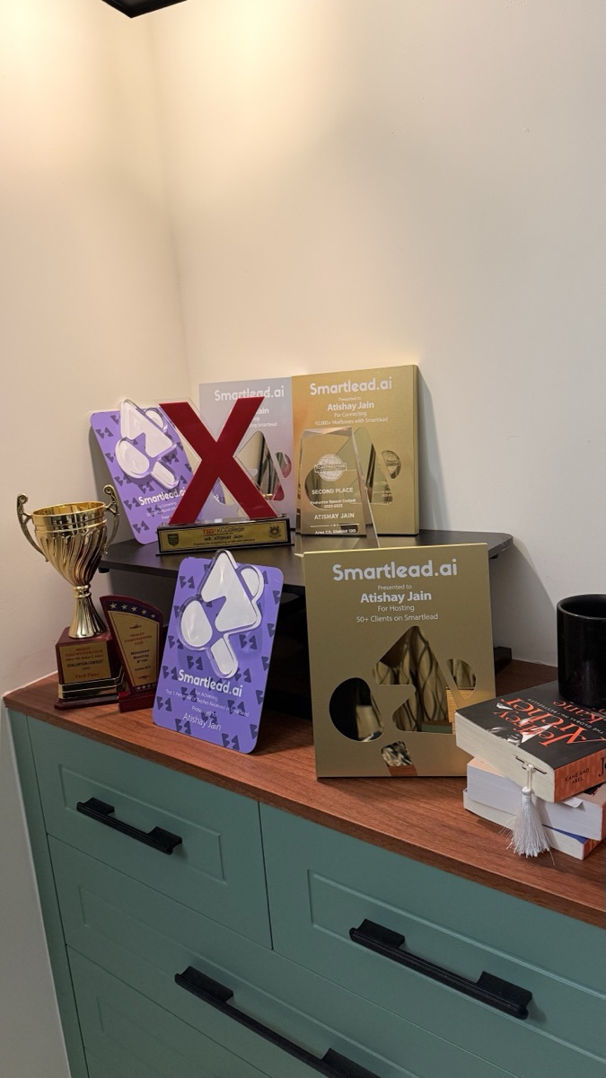 Trophies and Smartlead.ai partner plaques on Atishay Jain's recognition shelf.